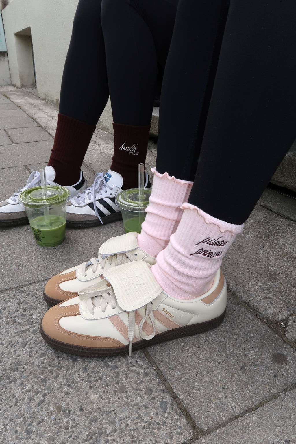 Rosa „Pilates Princess“-Socken mit Herz-Noppen und Retro-Sneakern, neben espressofarbenen „Health Club“-Socken