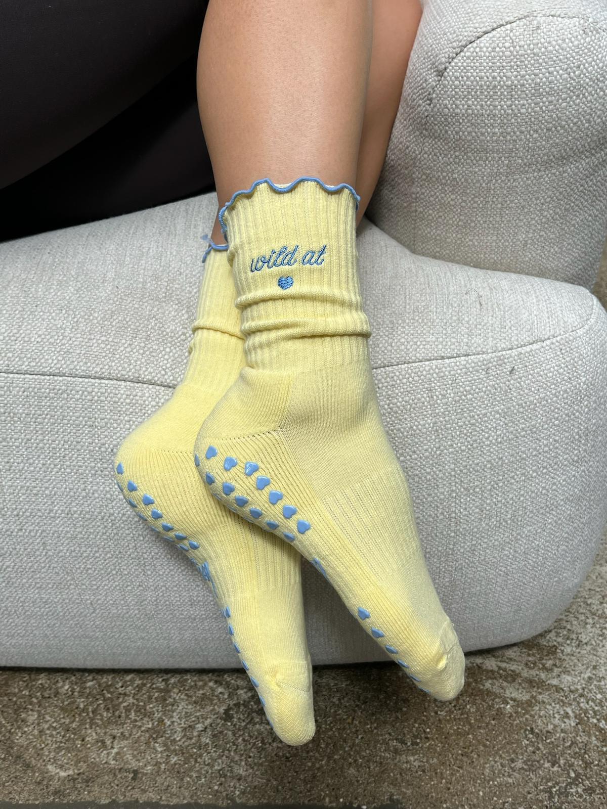 Butter yellow Pilates-Socken mit blauen Anti-Rutsch-Herzen und gesticktem Schriftzug "wild at heart"